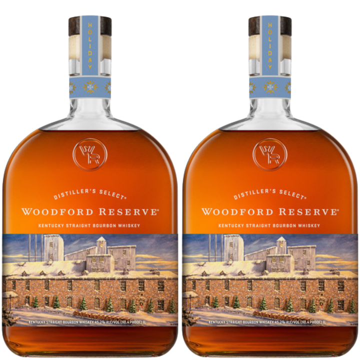 Two bottles of Woodford Reserve Bourbon Holiday Edition 2026 750ml, with a distillery illustration and light blue festive neck labels, are placed side by side.