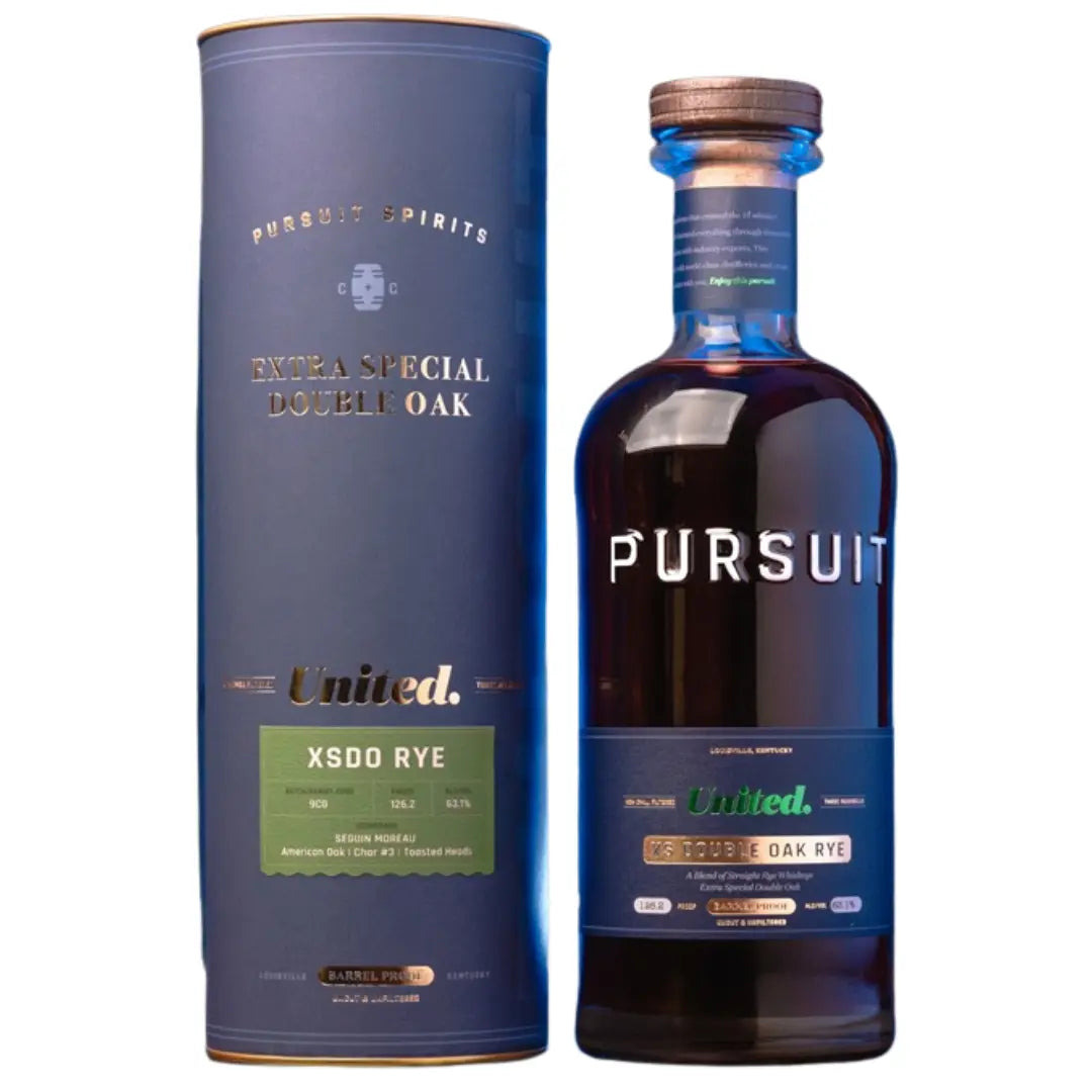 A bottle of Pursuit United XS Double Oak Rye Whiskey Barrel Proof and its matching dark blue cylindrical canister, both featuring labels detailing the blend, proof, and barrel information.