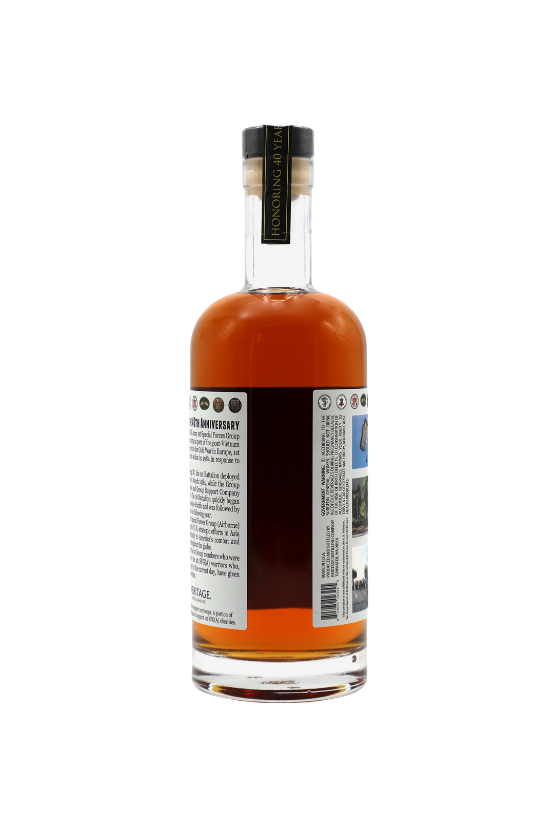 A bottle of amber 1st Special Forces Group Whiskey (8th Edition) by Heritage Distilling, with a black cap, is shown from the back. The label displays text and images; the neck reads "HONORING 10 YEARS." Bourbon Rye blend on a white background.