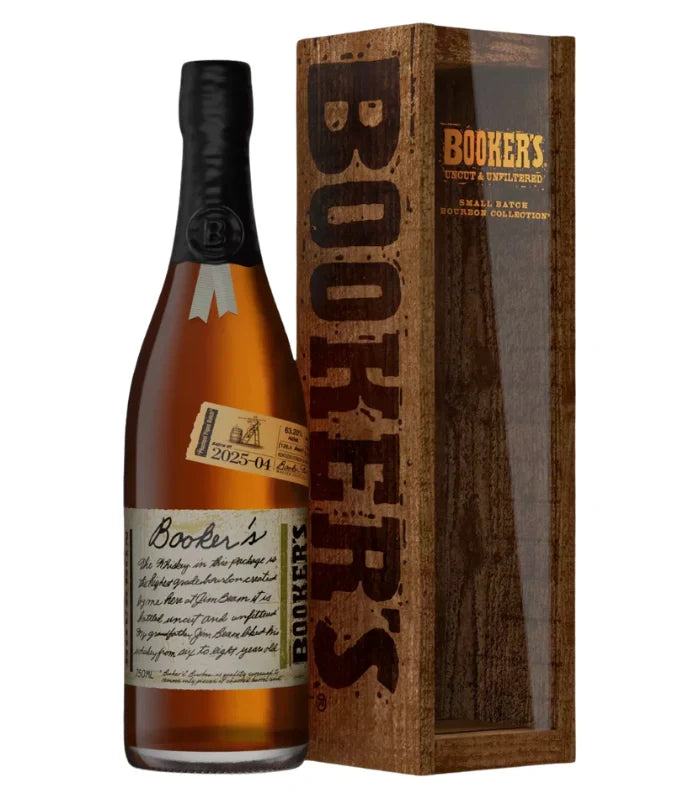 A bottle of Booker’s Bourbon Batch 2025-04 "Phantom Pipes Batch" with a handwritten-style label sits beside its wooden display box from Booker's Small Batch Collection, featuring BOOKERS vertically and a transparent front panel.