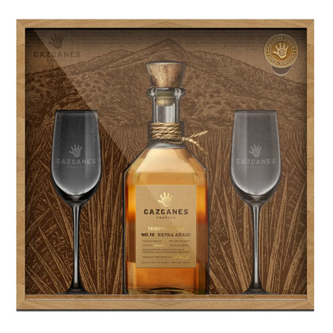 A collector set featuring Cazcanes No. 10 Extra Añejo Tributo Edition Tequila 750mL Gift Set (Pre-Order) with two elegant stemmed glasses, all from Cazcanes Tequila in a mountain-themed display.