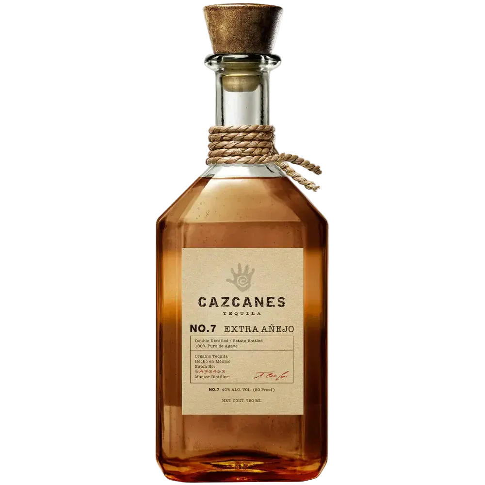 A bottle of Cazcanes No.7 Extra Añejo Tequila by Cazcanes Tequila features a cork stopper with rope detail, displays the Cazcanes logo in the top right corner, and is crafted from blue Weber agave in Jalisco.