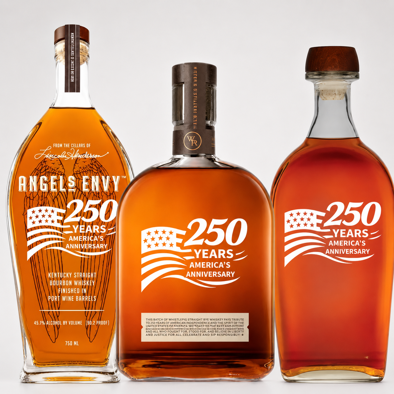 Three bottles from Main Street Liquor’s America’s 250th Anniversary Bourbon Patriot Bundle—Angel’s Envy, Woodford Reserve, and Elijah Craig—stand in a row with commemorative labels and an American flag design on a white background.