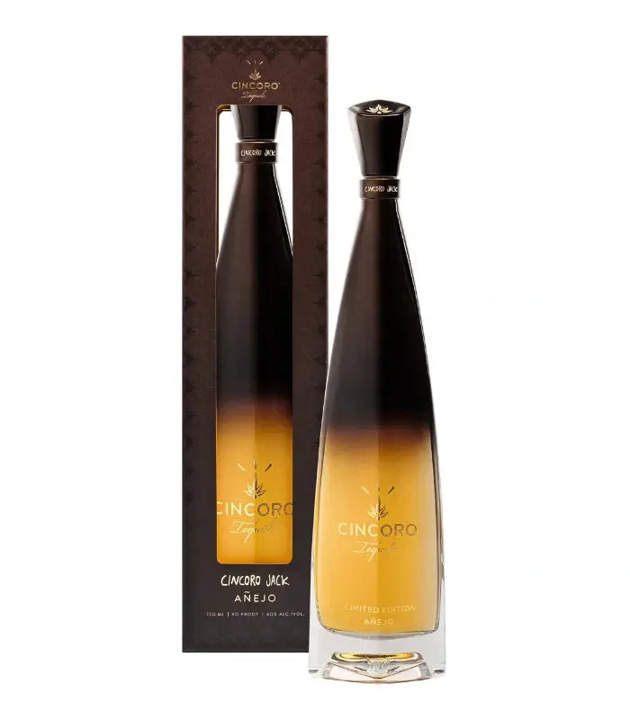 The Cincoro Jack Anejo Tequila Travis Scott Limited Edition by Cincoro Tequila features a tall, elegant bottle with a black-to-gold gradient and matching box with gold lettering, highlighting its exclusive, premium design.