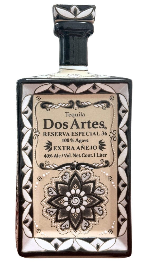 A decorative 1L bottle of Dos Artes Extra Añejo Reserva Especial Tequila, in a hand-painted ceramic decanter with beige and black floral design, labeled 100% Agave, 40% Alc/Vol.