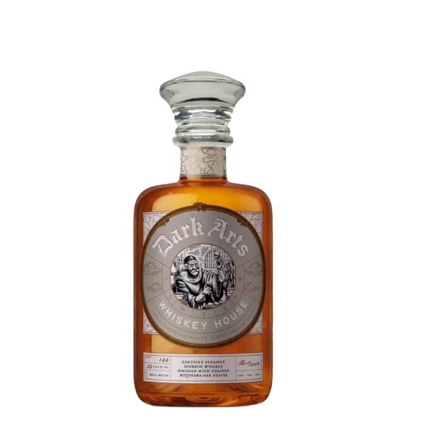A bottle of Dark Arts Whiskey House Kentucky Straight Bourbon Finished with Mizunara Oak Staves features amber liquid, a wide glass stopper, and a silver embossed label with a wizard illustration and decorative details.