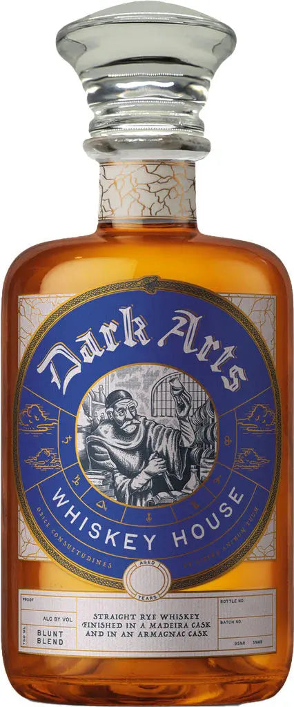A glass bottle of Dark Arts Whiskey House 8 Year Blunt Blend Rye, finished in Madeira, Armagnac & honey casks, features amber liquid and a blue and gold label with a robed figure writing at a desk and decorative details.