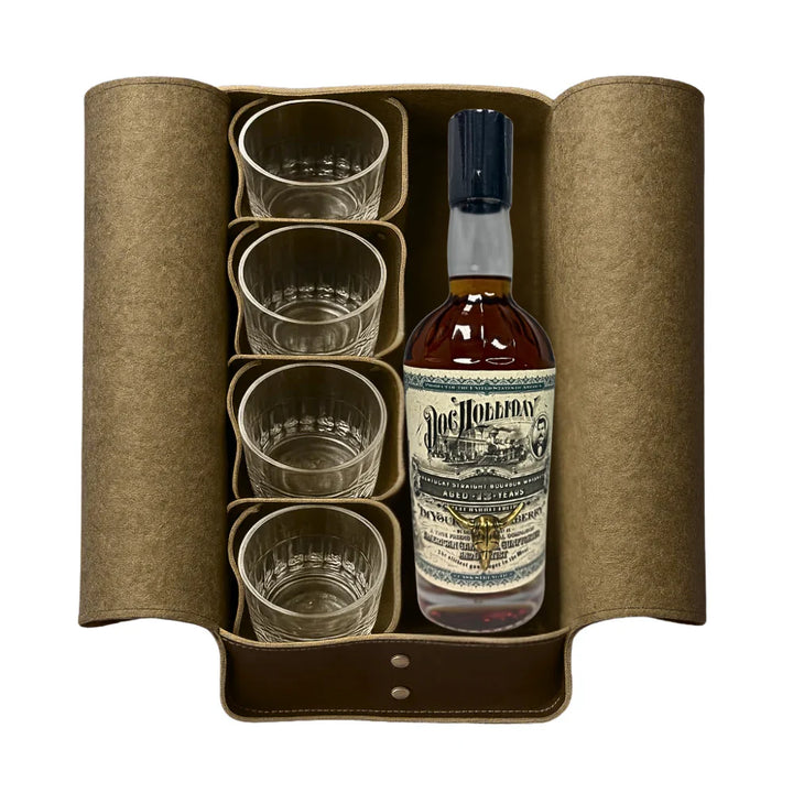 A brown leather case holds four clear glasses and a bottle of Doc Holliday 13 Year Doctor's Bag Single Barrel Bourbon by Doc Holliday, featuring a decorative label—perfect for enjoying premium bourbon in style.