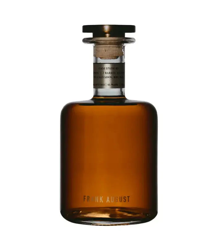 A clear glass decanter with a wide base, short neck, and round stopper contains amber liquid. The label reads "Case Study 07 French Connection Bourbon Whiskey" by Frank August, premium American bourbon.