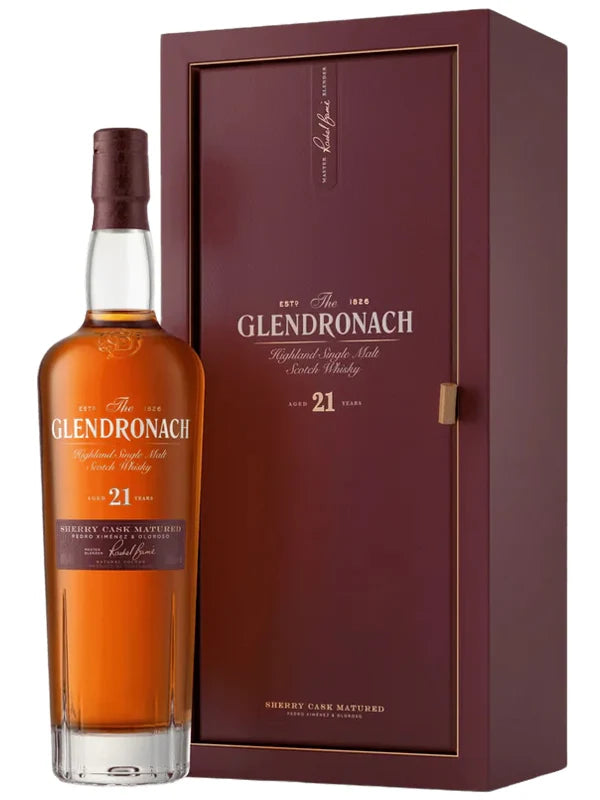 A bottle of The GlenDronach 21 Year Highland Single Malt Scotch Whisky Sherry Cask Matured by Glendronach is positioned next to its matching maroon display box, both adorned with gold and white label text and refined detailing.