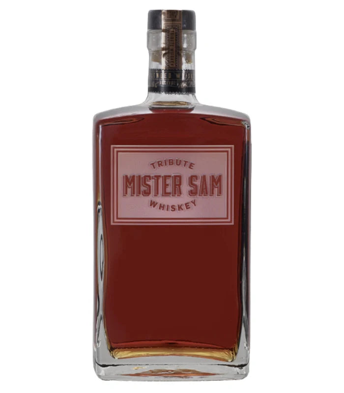 A rectangular glass bottle of Sazerac’s Mister Sam Tribute Whiskey Second Edition, filled with amber liquid, features red and gold labeling and a black and gold cap.