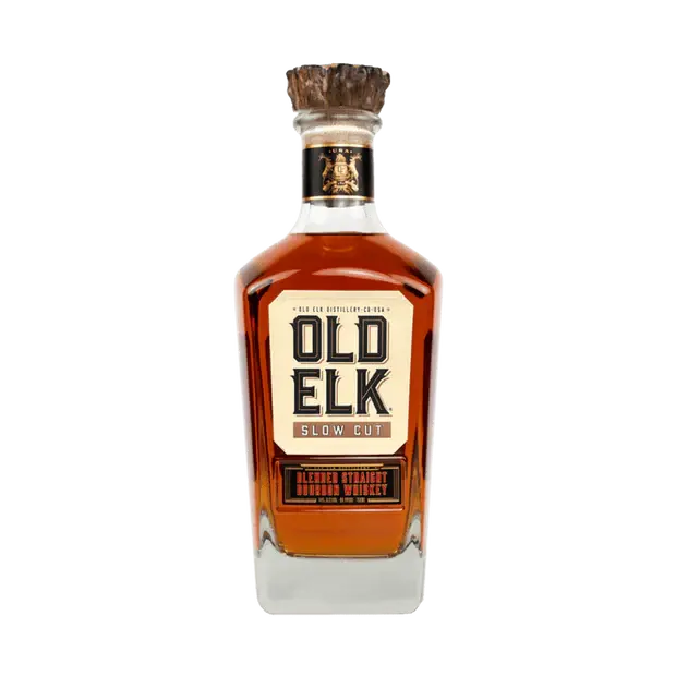 A 750ml bottle of Old Elk Slow Cut Blended Straight Bourbon Whiskey by Old Elk Bourbon, featuring a square clear glass design, rich amber color, wooden cork, and a cream label with bold black and gold text.