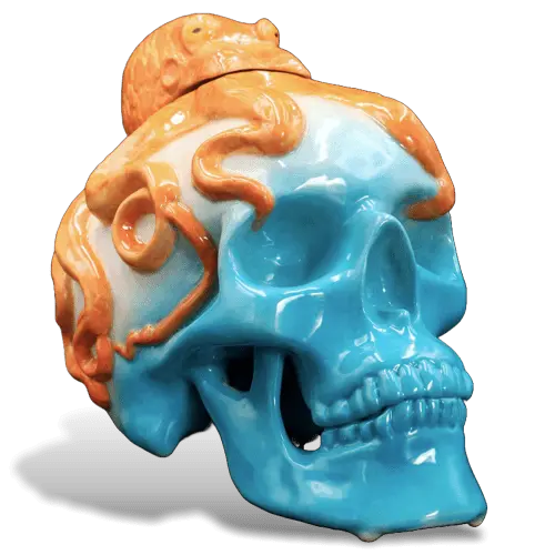 The OctoBlue Reposado Tequila bottle by OctoBlue Tequila features a ceramic skull painted in blue and white, adorned with vivid orange octopus tentacles and a fish on top, inspired by premium 100% agave tequila, set against a plain white background.