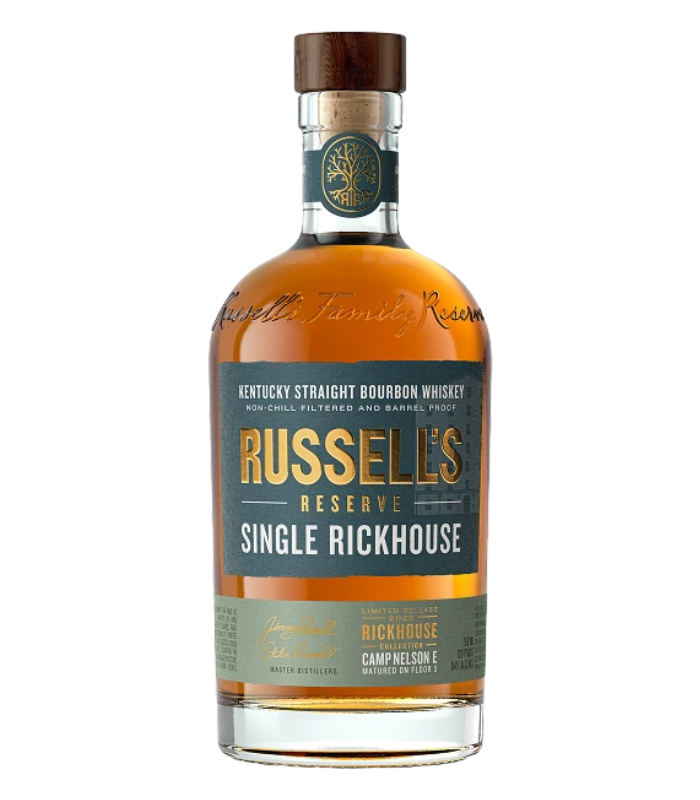 A bottle of Wild Turkey Russell’s Reserve Single Rickhouse 2025 Camp Nelson E Bourbon Whiskey with a brown cap, clear glass, and a green and gold label featuring product details.