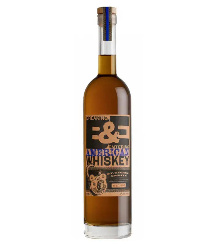 St. George Breaking & Entering American Whiskey comes in a tall, clear glass bottle with an illustrated bear on the black, gold, and blue label. This blended whiskey from St. George Spirits is amber-colored and sealed with a cork.