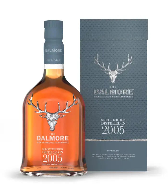 A bottle of The Dalmore Select Edition Distilled in 2005 stands before its coordinating blue-gray box, each emblazoned with The Dalmore’s silver stag logo and white lettering highlighting the product name and vintage.