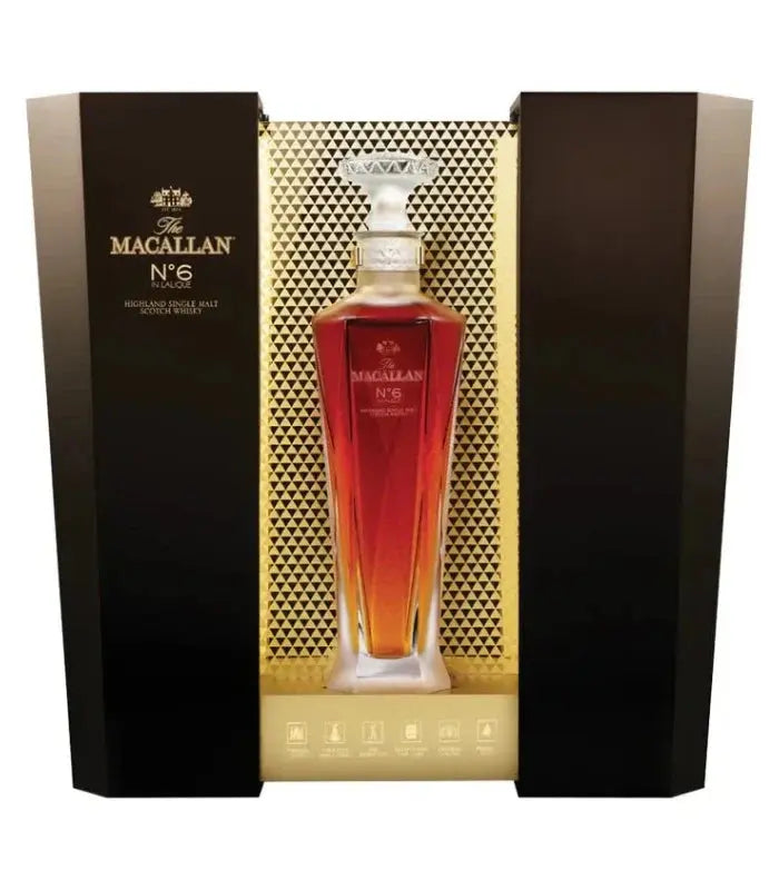 A bottle of The Macallan No. 6 Lalique Single Malt Scotch Whiskey by The Macallan, presented in a luxury crystal decanter and displayed in an elegant black and gold box with geometric patterns.