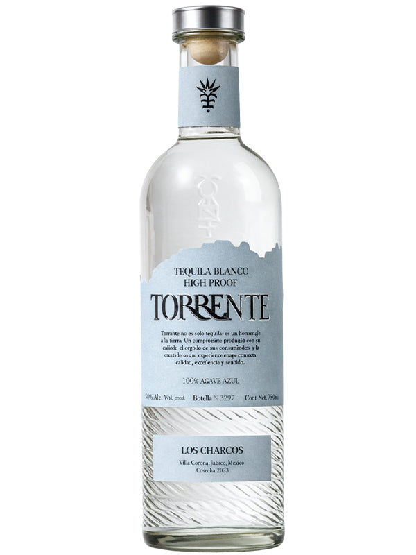 A clear glass bottle of Torrente High Proof Blanco Tequila by Torrente, crafted from 100% Blue Weber agave, featuring a blue and white label with origin and high alcohol content details, a wooden cork top, and an embossed agave logo.