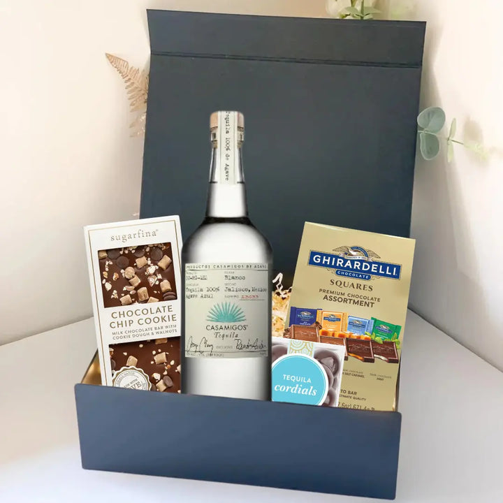 The Premium Tequila Gift Box by Main Street Liquor features Casamigos tequila, a Sugarfina chocolate chip cookie bar, and Ghirardelli gourmet chocolate squares, all upright in an elegant display.