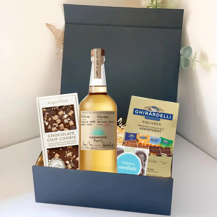 The Premium Tequila Gift Box by Main Street Liquor includes Casamigos tequila, Sugarfina chocolate chip cookie bites, Ghirardelli chocolate squares, and tequila cordials, all beautifully presented in a sleek black box.