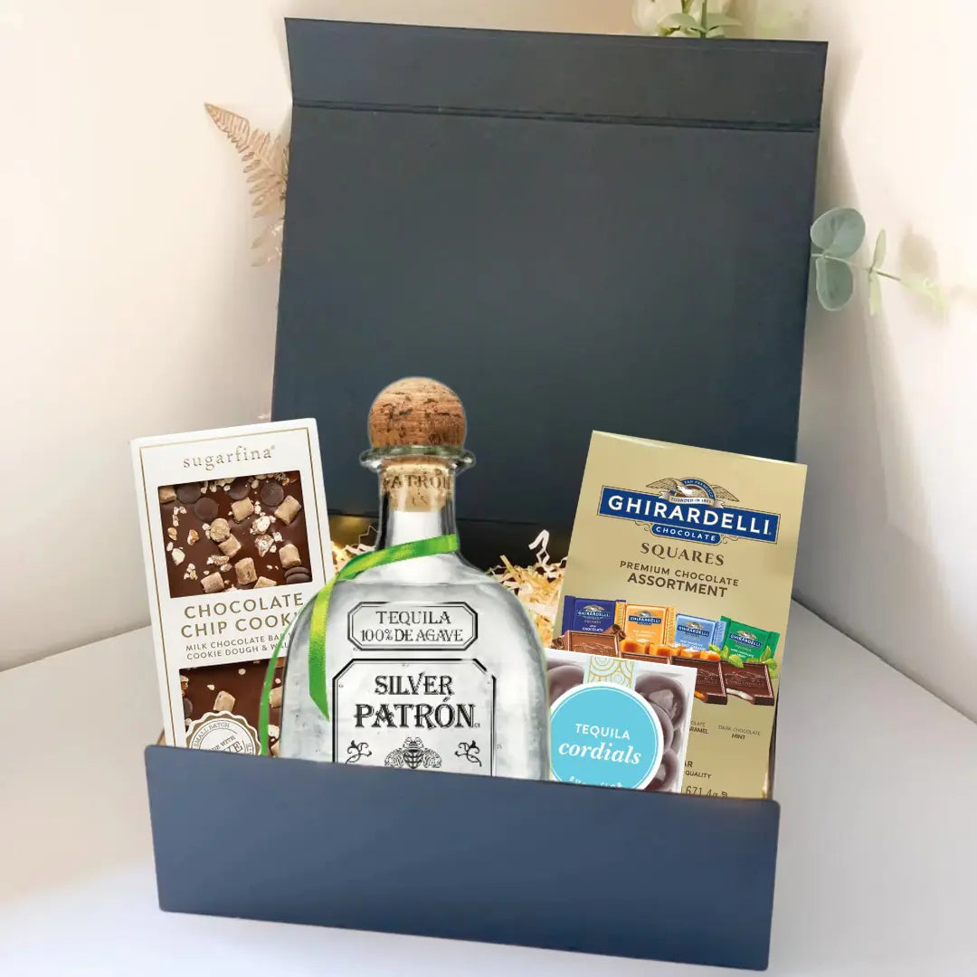 The Premium Tequila Gift Box by Main Street Liquor includes Patrón Silver, gourmet chocolate chip cookies, Ghirardelli chocolate squares, and tequila-flavored cordials in a sleek black box.