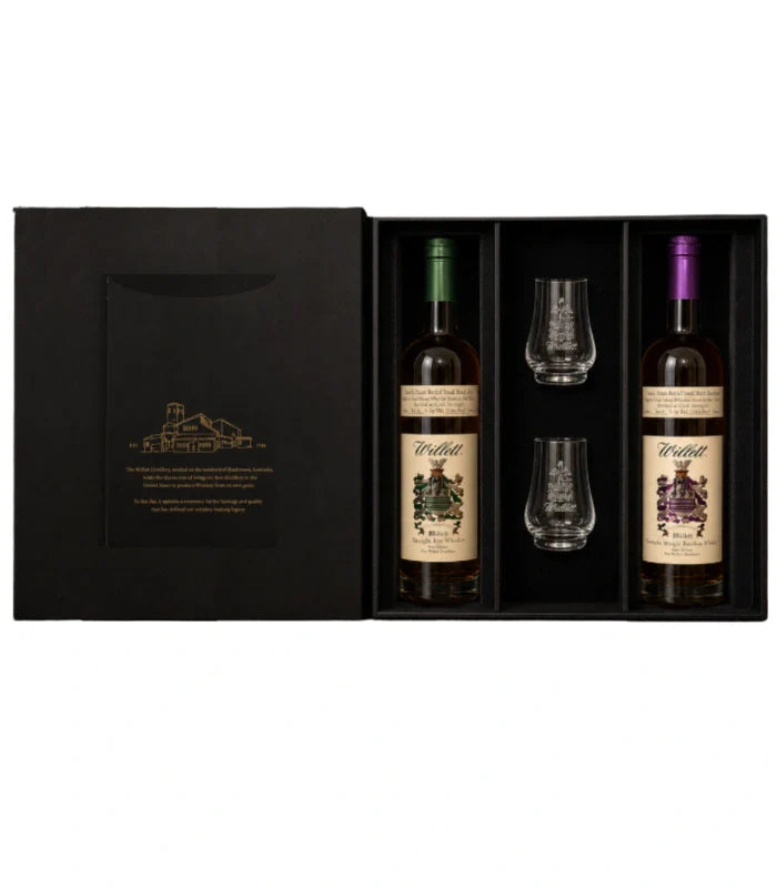 The Willett Distillery Family Estate 2-Bottle Gift Set (750mL) includes bourbon and rye, each with colored caps, plus two Willett glasses, all organized in separate compartments.