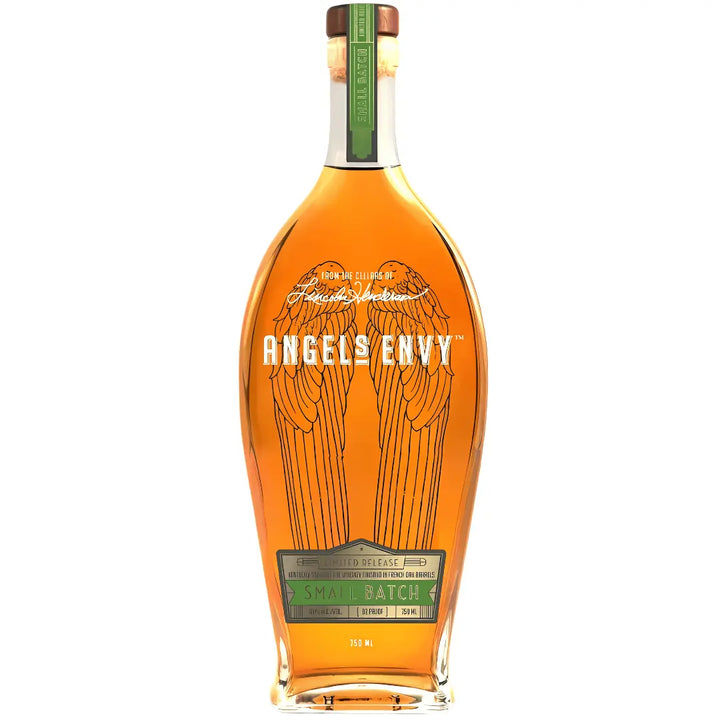 A tall, clear bottle of Angel's Envy Unique & Rare Rye Whiskey Finished In French Oak Barrels features etched angel wings, a green “Small Batch” label, brown cap with green seal, and rich amber Kentucky straight rye whiskey inside.