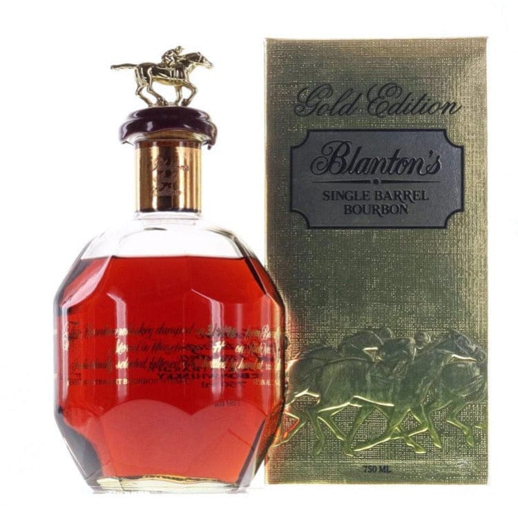 A bottle of Blanton's Takara Gold Japanese Edition Single Barrel Bourbon with a horse-shaped stopper, shown beside its gold box embossed with horses and Blanton's branding.