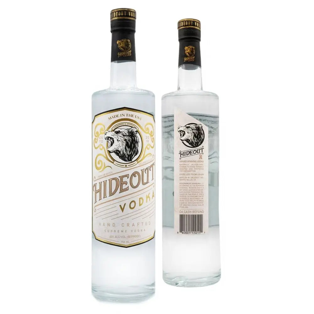 Two bottles of Hideout Vodka are displayed, with one showing the front and the other the back of the label. The label displays a bear’s head with gold accents and notes that this is Hiedout 80 Proof Premium Vodka, handcrafted in the USA.