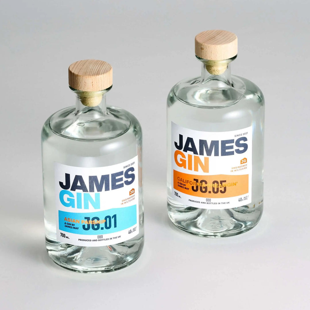 Two clear James Gin US bottles—The Internationalist 700ml editions (Asian Parsnip 73:01 and California 08:05)—come with a wooden cap, blue and orange accents, plus a souvenir gift key chain. Ideal for gin enthusiasts.