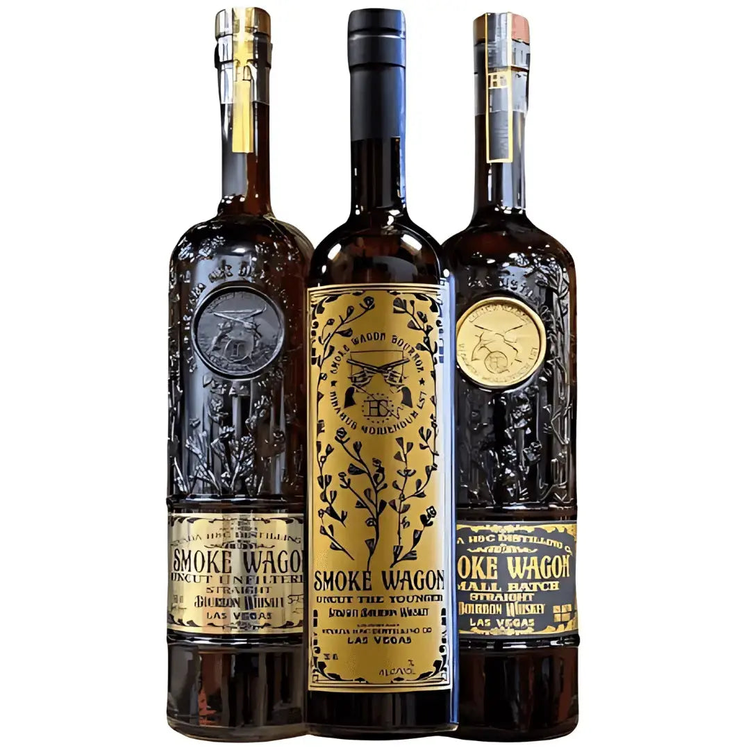 Three ornate bottles of Smoke Wagon Bourbon—Uncut Unfiltered, Desert Colt Straight Bourbon, and Small Batch—stand side by side, showcasing the rich character and expert craftsmanship of this distinguished bundle.