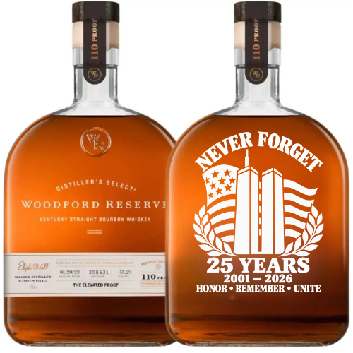 Displayed are two Woodford Reserve bourbon bottles: one presents the traditional label, while the other is the Woodford Reserve 110 Proof 9/11 Never Forget 25th Anniversary Memorial Edition. This special release features a hand-painted design with “Never Forget,” “25 Years, 2001-2026,” vibrantly illustrated twin towers, an American flag, and detailed stars. The powerful tribute is completed by “Honor Remember Unite” at the base, making this commemorative bottle from Woodford Reserve especially meaningful.